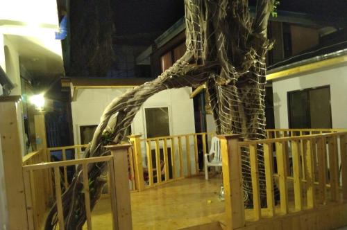 a fake tree on a deck with a house at Monallan Boracay Hotel in Boracay