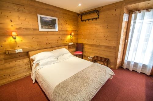 um quarto com uma cama numa parede de madeira em Apartment Jazz - La Terrasse de Verchaix em Verchaix