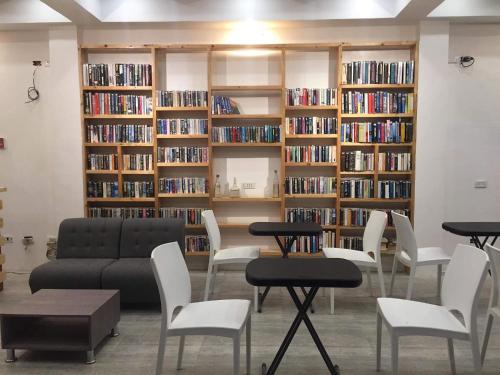 a library with white chairs and a couch and bookshelves at Monallan Boracay Hotel in Boracay