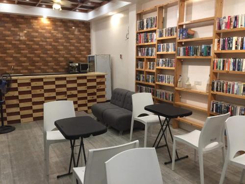 a library with white chairs and a couch and bookshelves at Monallan Boracay Hotel in Boracay