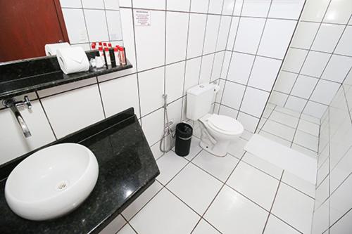 a white bathroom with a sink and a toilet at Hotel Pousada Bonsai in Bonito