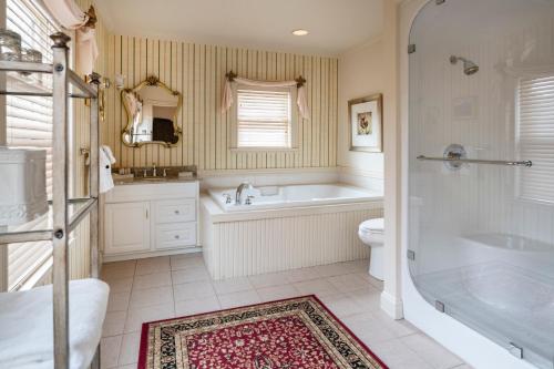a bathroom with a tub and a toilet and a sink at The Inn at Thorn Hill in Jackson