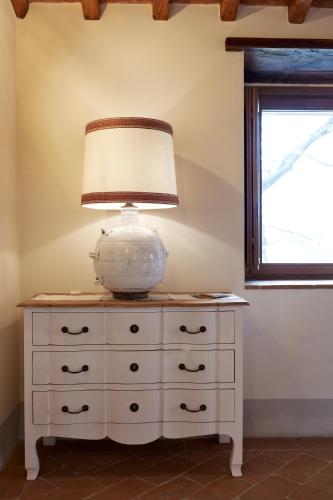 a white dresser with a lamp on top of it at Podere di Moiata in Campestri