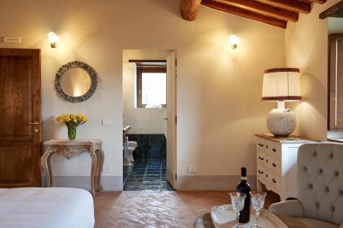 a bedroom with a bed and a table and a mirror at Podere di Moiata in Campestri