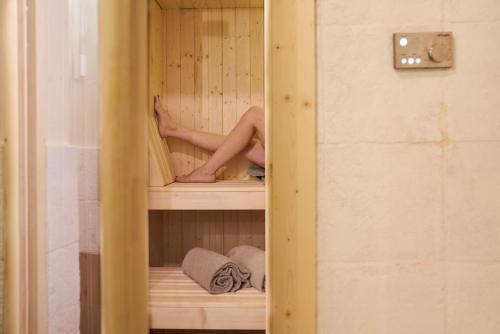 a woman is sitting in a sauna with her feet up at Podere di Moiata in Campestri