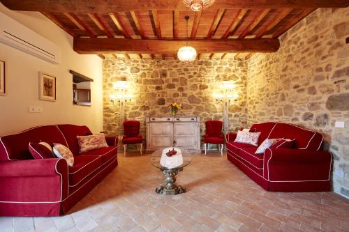 a living room with two red couches and a table at Podere di Moiata in Campestri