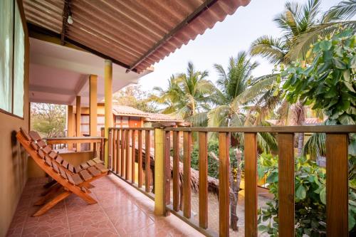 einen Balkon eines Hauses mit einer Bank darauf in der Unterkunft OYO Cabañas Abril, Mazunte in Mazunte