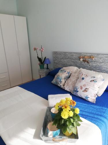 a bed with a tray with a bouquet of flowers on it at Le Torrette di Anna - Tropea in Briatico
