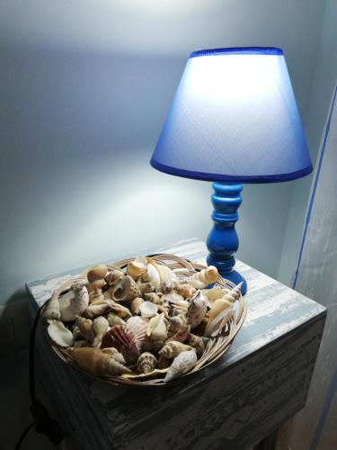 a table with a lamp and a bowl of shells at Le Torrette di Anna - Tropea in Briatico