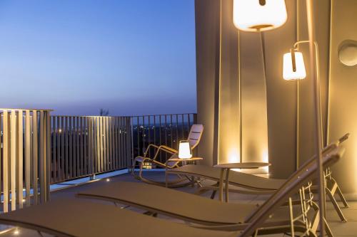 a room with a balcony with chairs and tables at hirschen dornbirn - das boutiquestyle hotel - skyrelax & wellness im rooftop in Dornbirn