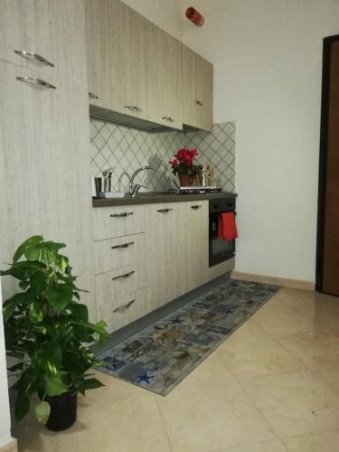 a kitchen with white cabinets and a tile floor at Le Torrette di Anna - Tropea in Briatico