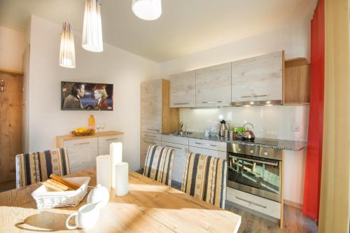 a kitchen with a wooden table and a dining room at Bergparadies - inklusive Eintritt in die Alpentherme in Dorfgastein