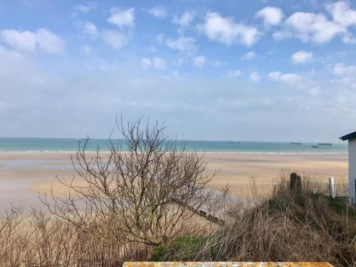 a view of a beach with the ocean in the background at La Villa Port Winston - Face Mer B&B in Saint-Côme-de-Fresné