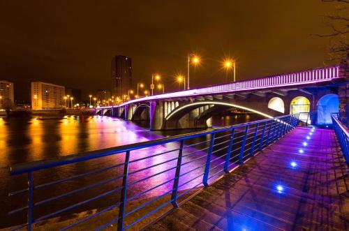 a bridge over a river at night with purple lights at Studio des jardins suspendus in Liège