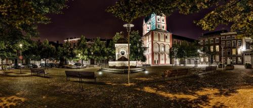 a building with a clock tower in a city at night at Studio des jardins suspendus in Liège