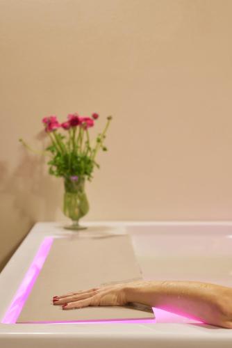 a vase with flowers and a hand on a table at Podere di Moiata in Campestri