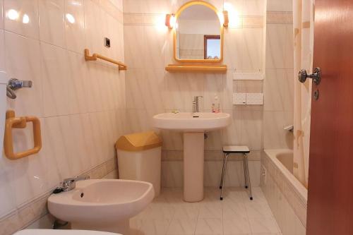a white bathroom with a sink and a toilet at LovelyStay - The Algarvean Oasis in Armação de Pêra