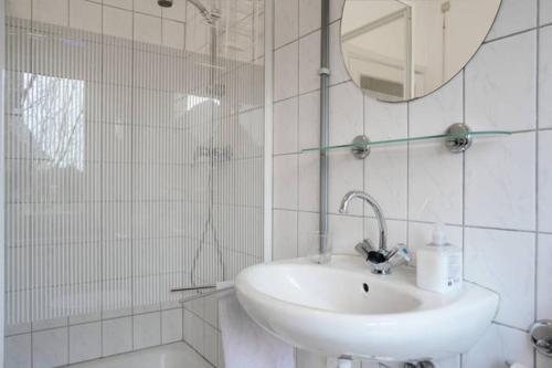 a white bathroom with a sink and a mirror at House Hommert Hoensbroek in Hoensbroek