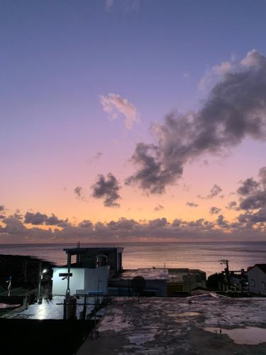 a sunset over the water with a building and the ocean at That day Hostel 那天旅宿 in Lanyu