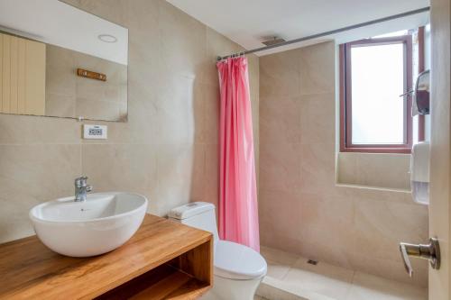bagno con lavandino, servizi igienici e finestra di Selina Baños a Baños