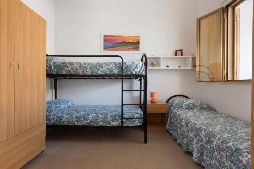 a bedroom with two bunk beds and a desk at Villetta Solaire a 40 mt dalla spiaggia by BarbarHouse in Torre Lapillo