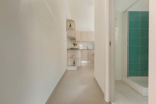 a hallway with white walls and a green tile floor at Villetta Solaire a 40 mt dalla spiaggia by BarbarHouse in Torre Lapillo