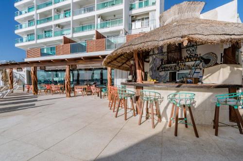 a bar on the beach with chairs and a building at Ocean Dream Cancun by GuruHotel in Cancún