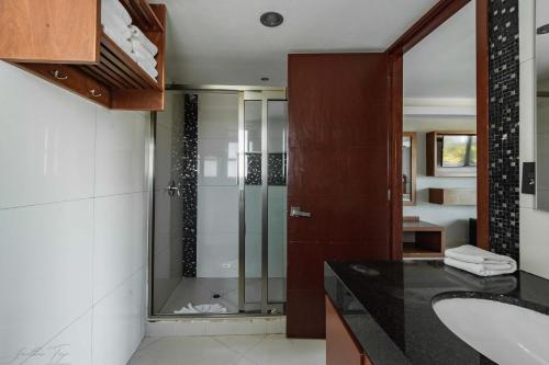 a bathroom with a glass shower and a sink at Ocean Dream Cancun by GuruHotel in Cancún