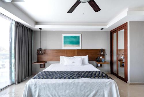 a bedroom with a large bed and a ceiling fan at Ocean Dream Cancun by GuruHotel in Cancún