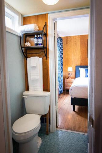 a bathroom with a toilet and a bedroom with a bed at Anchor Inn Resort in Lincoln City