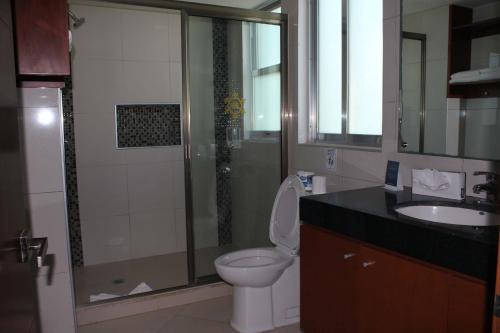 a bathroom with a shower and a toilet and a sink at Ocean Dream Cancun by GuruHotel in Cancún