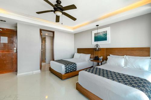 a hotel room with two beds and a ceiling fan at Ocean Dream Cancun by GuruHotel in Cancún