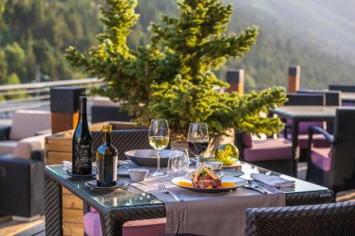 a table with wine glasses and a plate of food at Sport Hotel Village in Soldeu