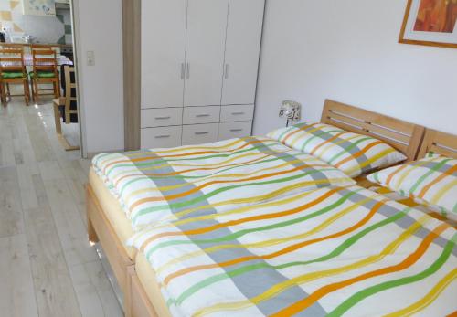 ein Bett mit einer bunten gestreiften Bettdecke in einem Schlafzimmer in der Unterkunft Ferienwohnung Sailer in Gmunden