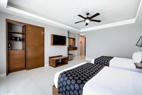 a bedroom with two beds and a ceiling fan at Ocean Dream Cancun by GuruHotel in Cancún