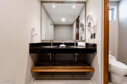 a bathroom with two sinks and a toilet at Ocean Dream Cancun by GuruHotel in Cancún
