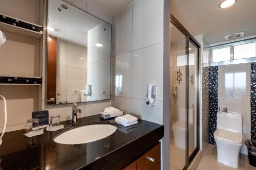 a bathroom with a sink and a toilet and a mirror at Ocean Dream Cancun by GuruHotel in Cancún