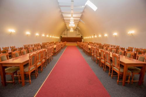 a conference room with tables and chairs and a red carpet at Hotel Koliba in Litoměřice