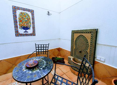 a room with a table and chairs and a painting at Triana Luxury Home in Seville