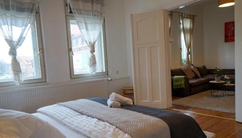 a bedroom with a bed and a couch and windows at Wohnung in Lüneburg in Lüneburg