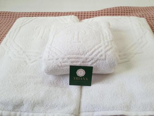a pile of white towels sitting on a bed at Triana Luxury Home in Seville