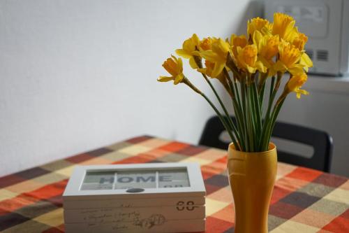 a vase of yellow flowers sitting on a table with a box at Wohnung in Lüneburg in Lüneburg