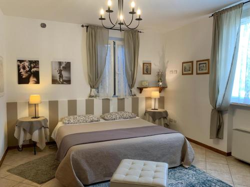 ein Schlafzimmer mit einem großen Bett und zwei Fenstern in der Unterkunft La Meridiana Affittacamere in Colorno