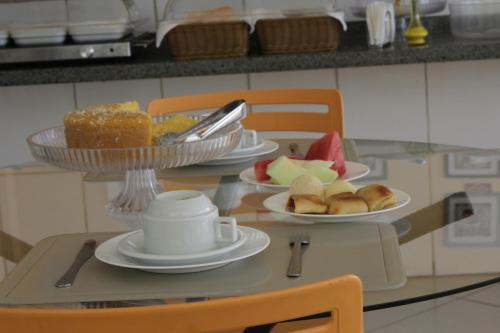 a glass table with plates of food on it at Mais Hotel in Araguaína