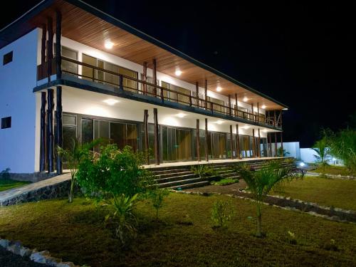 a large white building with a balcony at night at Lemon Beach Resort in Elmina
