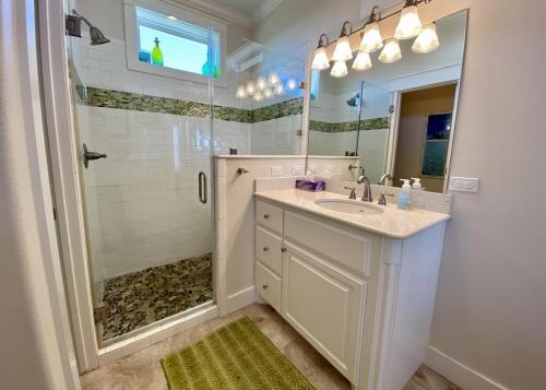 ein Badezimmer mit Waschbecken und Dusche mit Spiegel in der Unterkunft Sea Hag home in Stingaree