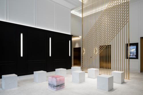 a lobby with white benches and a black wall at Four Seasons Hotel Montreal in Montreal