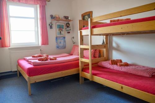 a bedroom with two bunk beds with red sheets at Apartments Rokytka 112 a 208 in Rokytnice nad Jizerou