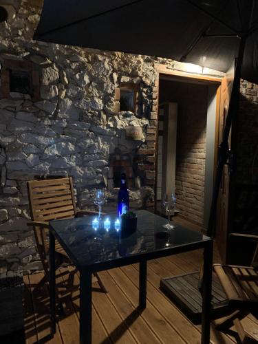 a table in a room with a stone wall at Siedlisko Kępina Zdrój in Ostrów