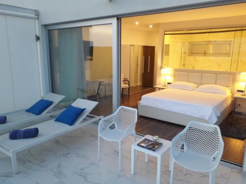 een slaapkamer met een bed en 2 stoelen en een tafel bij B&B Demar Residence & Dependance in Zadar